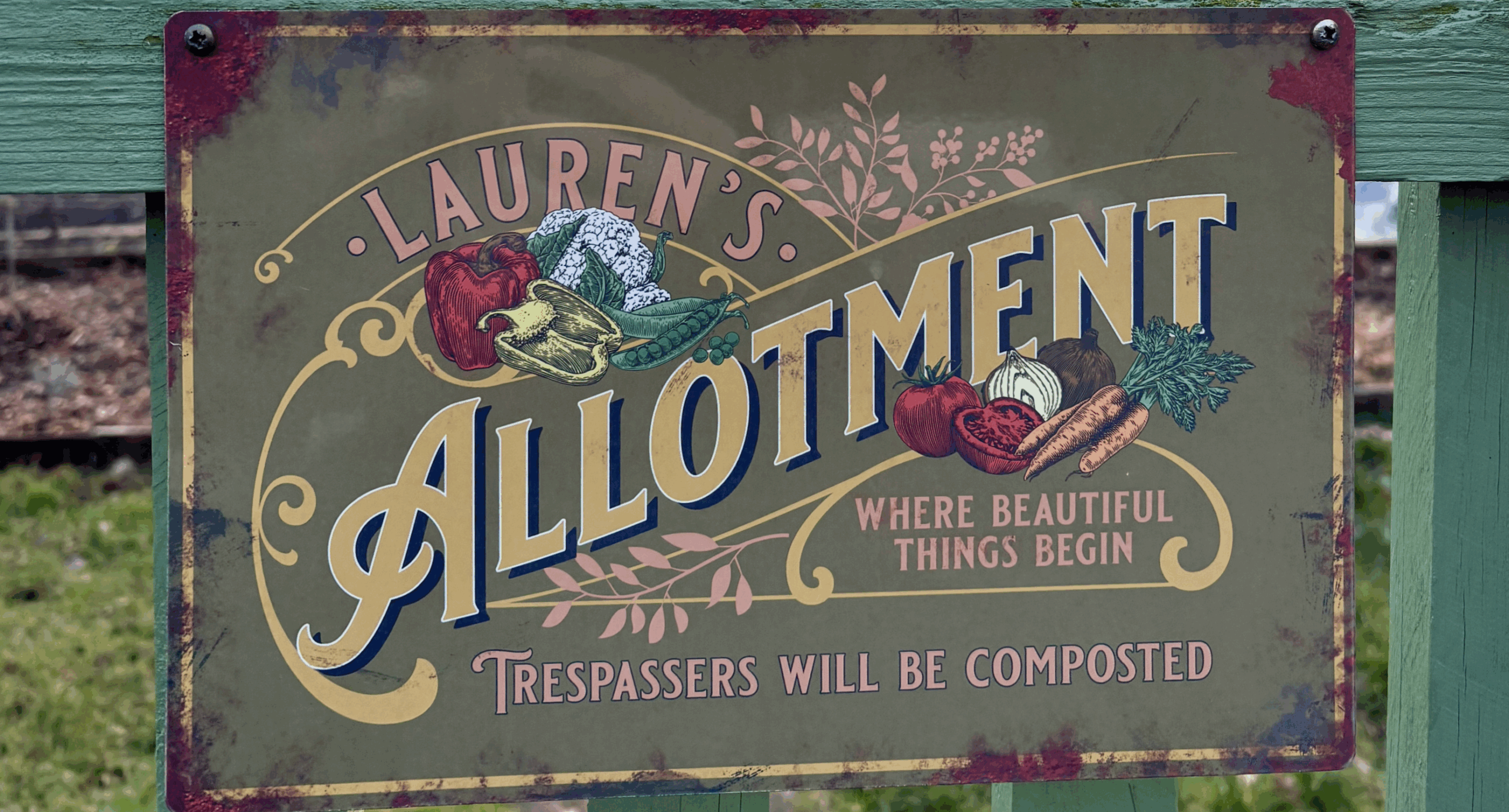 Laure's Allotment. Where beautiful things begin. Trespassers will be composted. Sign on a green gate.